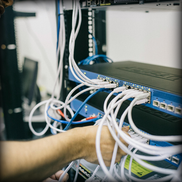 Technician wiring a structured voice and data patch panel for an A/Coe turnkey enterprise network installation.
