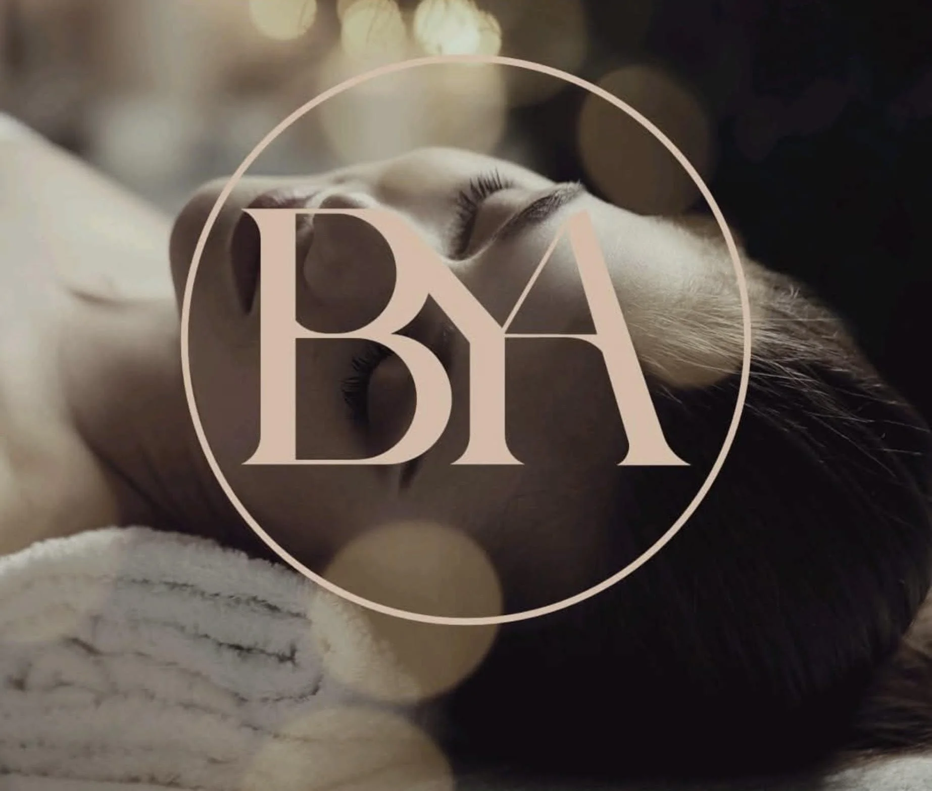 Close-up of a sleeping cat with a large, stylized 'BA' logo overlayed