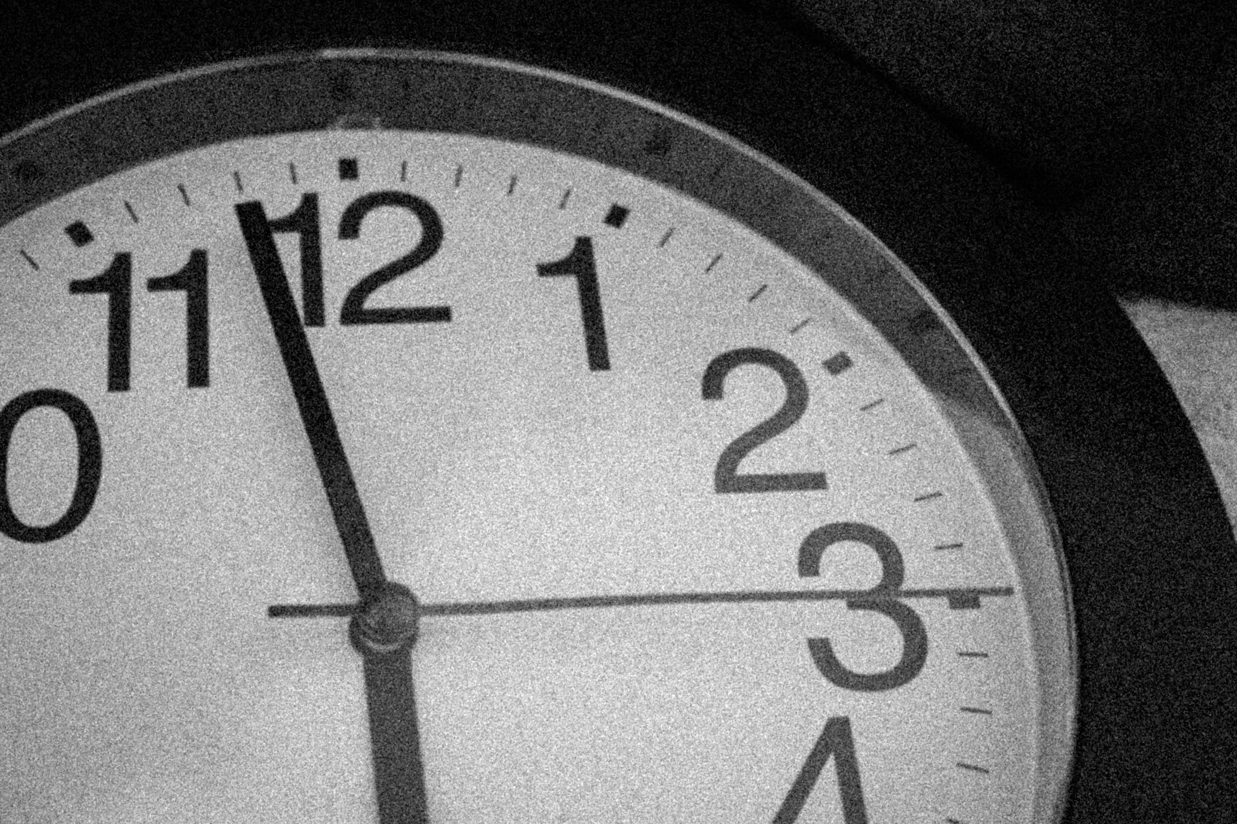 Close-up of a clock showing the time as approximately 11:59.