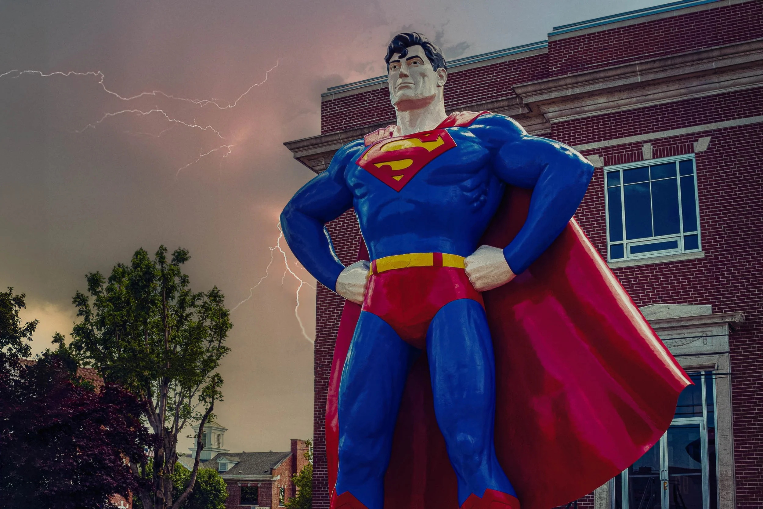 Giant Superman statue standing watch over a brick courthouse building as lightning splits a stormy sky, Metropolis, Illinois — fine art photography by Robert Niemeier.