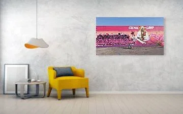Long magenta-to-peach mural wall in St. Louis with pink graffiti lettering at left, silhouetted palm trees, a seated white-robed figure under the words Genie of the Lamp and a brown lamp at right