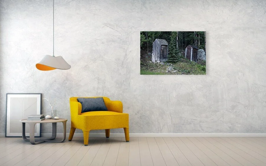 Occupied fine art print displayed above a yellow chair and small table