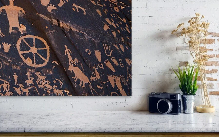 ledge)	Before the Alphabet, close-up detail of the fine art print above a marble ledge with a camera and a plant