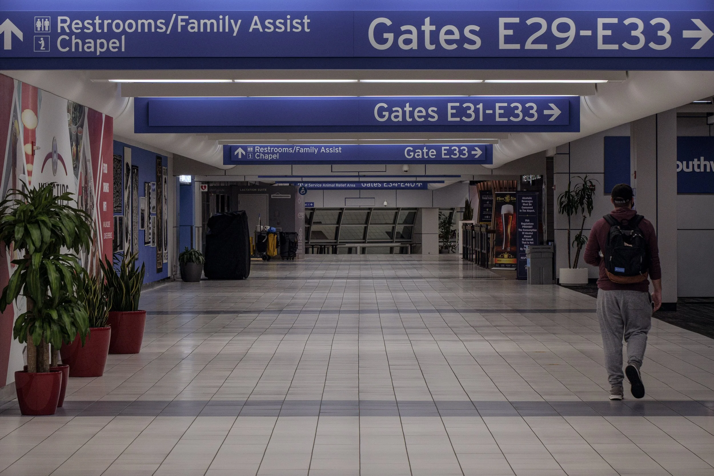 Lone traveler walking through Gate E33 concourse at Lambert International Airport, St. Louis — fine art travel photography