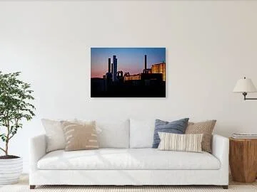 Last Light on the Line – industrial silhouette photograph of smokestacks and piping against a sunset gradient sky, one corrugated wall catching warm light