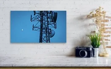 Between Signals – fine art photograph of a crescent moon beside a massive communications tower against a deep blue-violet twilight sky