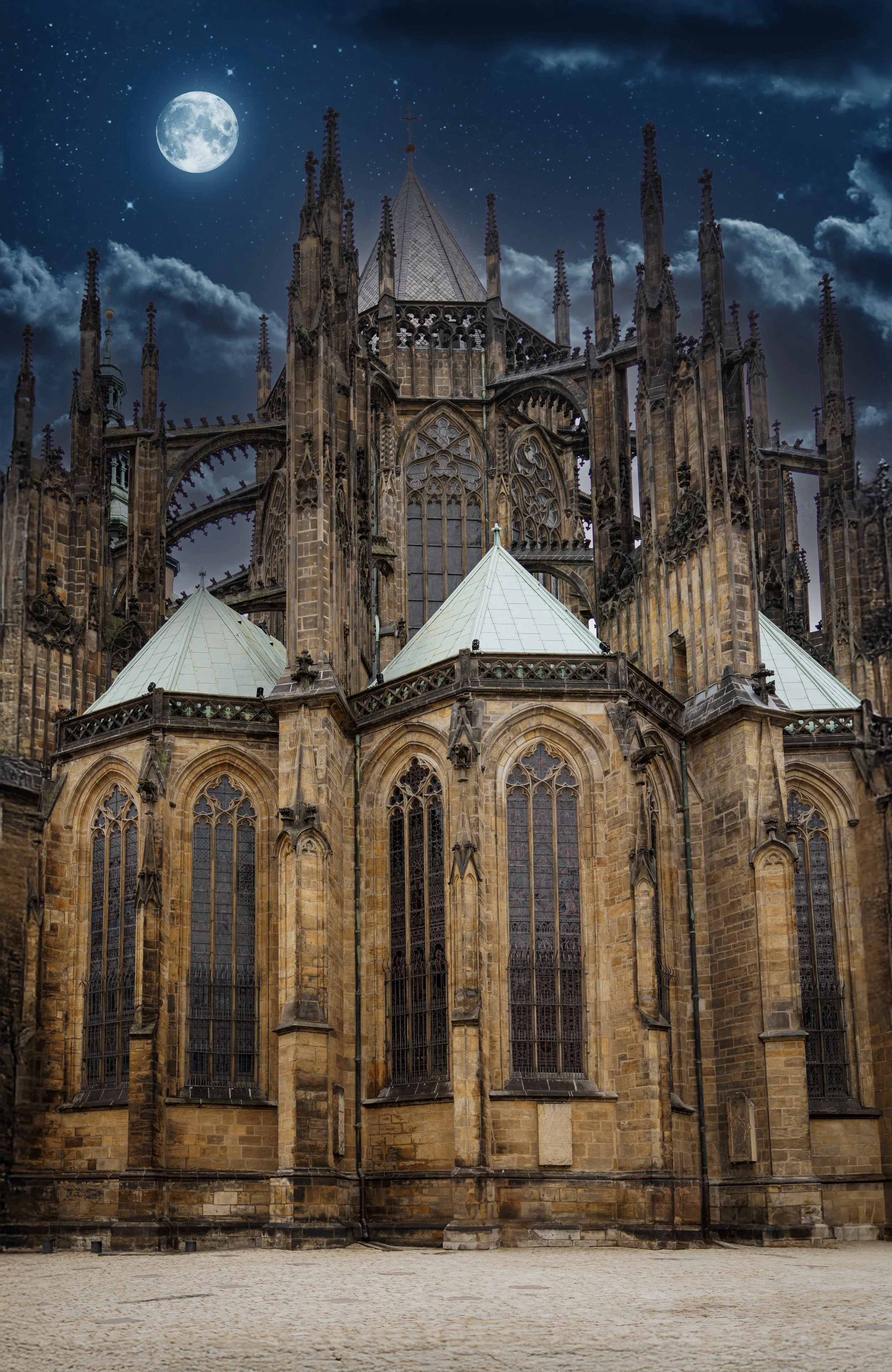 Fine art photograph of a Gothic cathedral in Vienna, Austria beneath a luminous moon and dramatic blue night clouds.