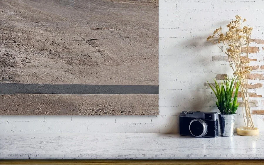 Detail: What the Crossing Remembers, close-up detail of the fine art print above a marble ledge with a camera and a plant