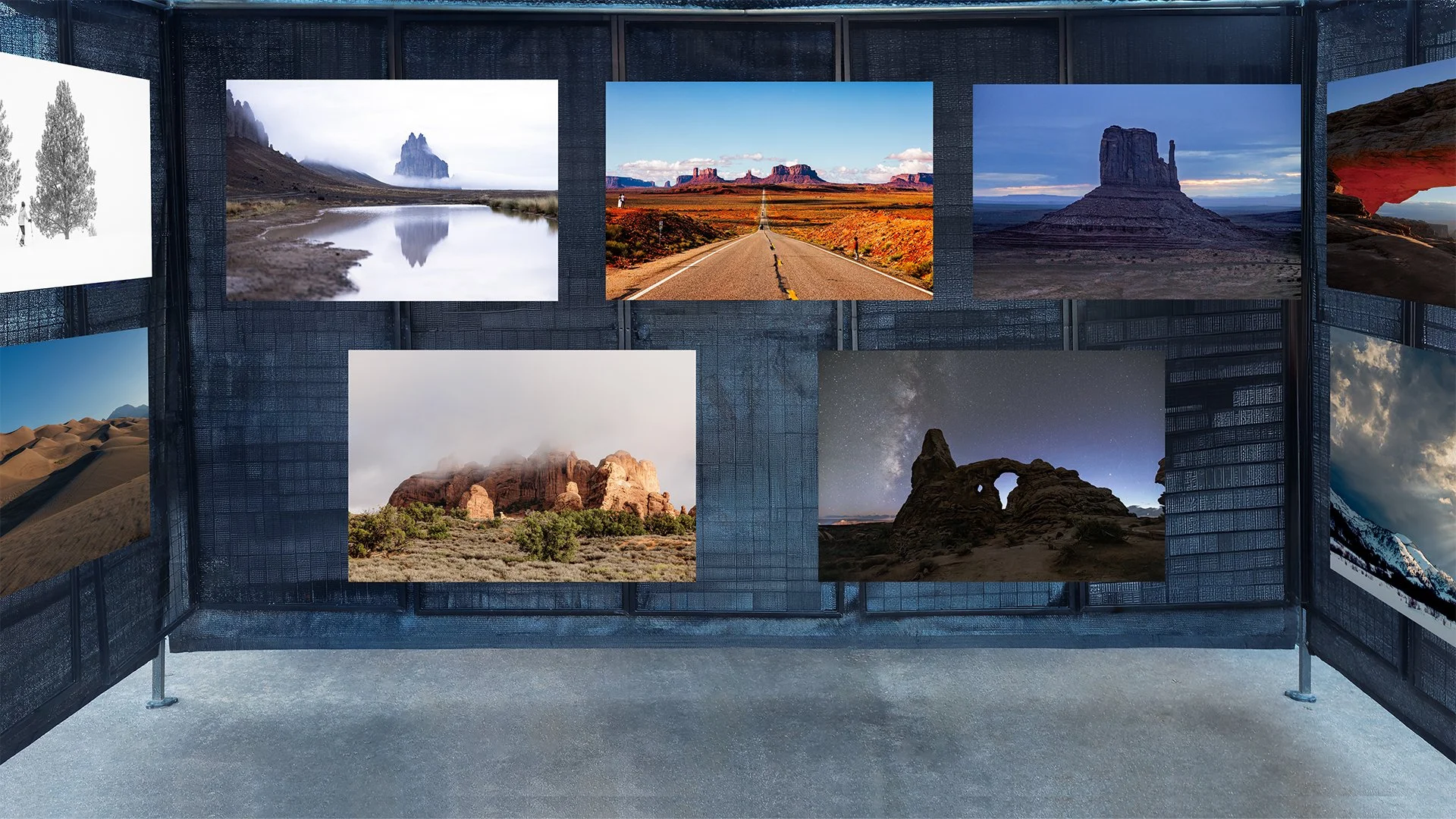 Exhibition of landscape photographs displayed on gallery walls, featuring desert, mountain, and canyon scenes in a modern art setting.