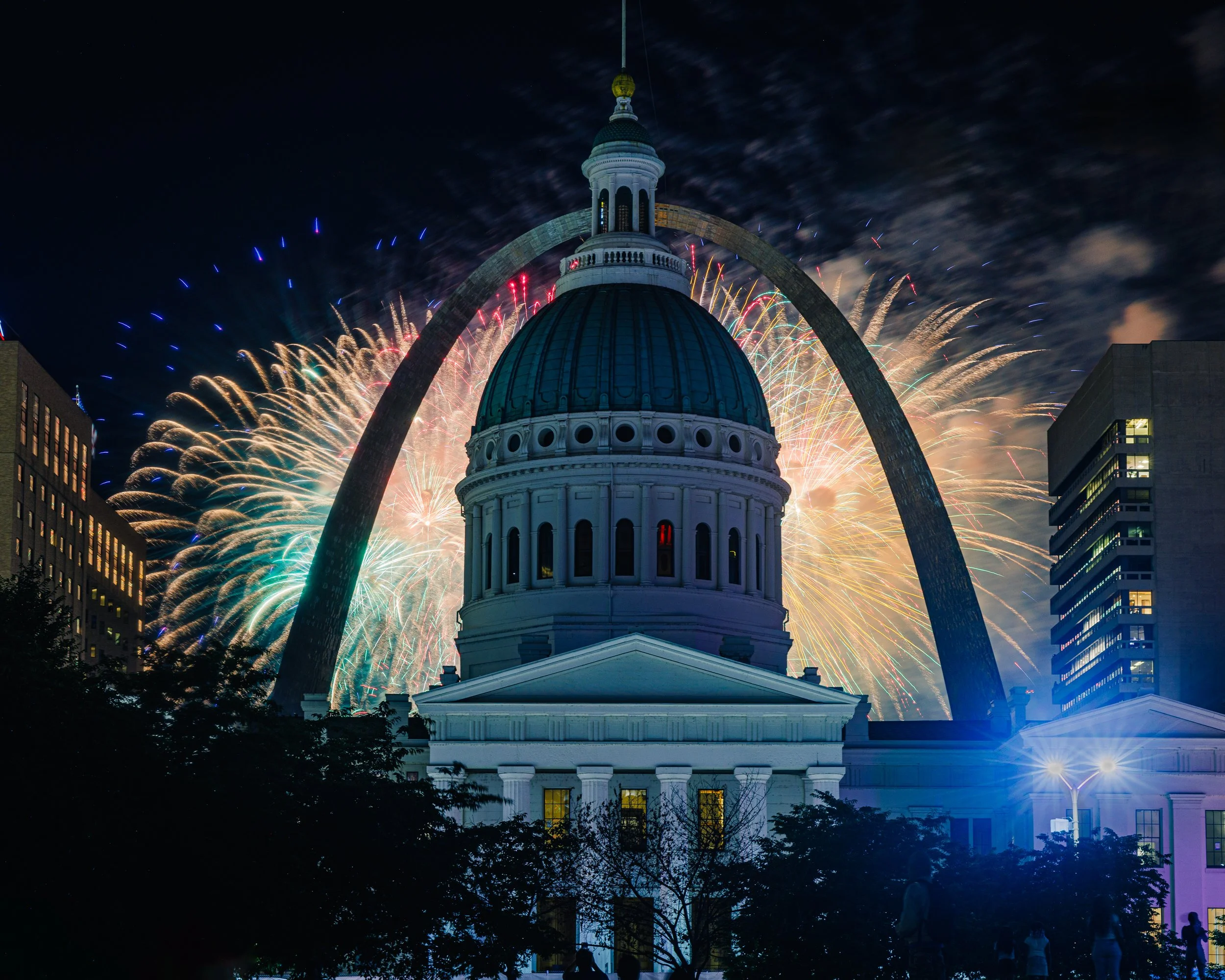 Fine art color landscape photography print capturing a vibrant fireworks display bursting over the St. Louis Gateway Arch and the historic dome of the Old Courthouse at night.