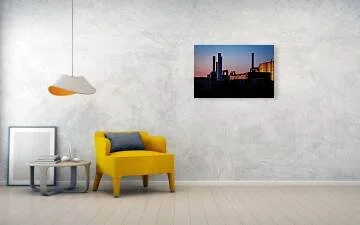 Last Light on the Line – industrial silhouette photograph of smokestacks and piping against a sunset gradient sky, one corrugated wall catching warm light