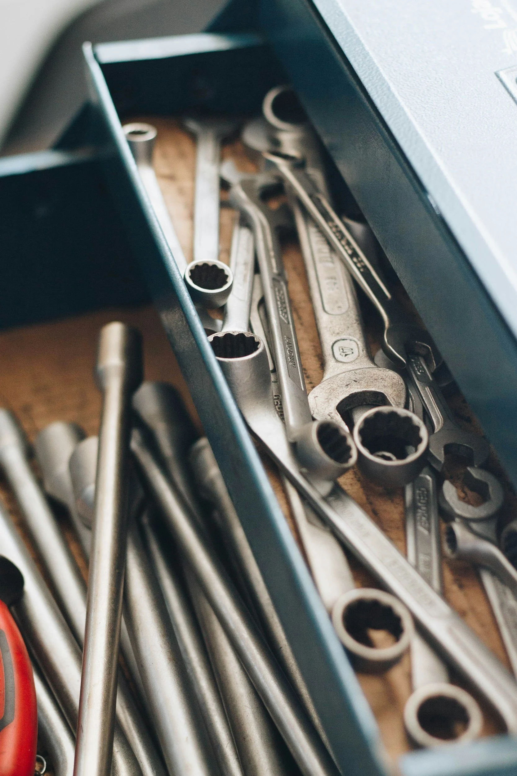 A collection of various hand tools including wrenches, sockets, and other tools in a tray.