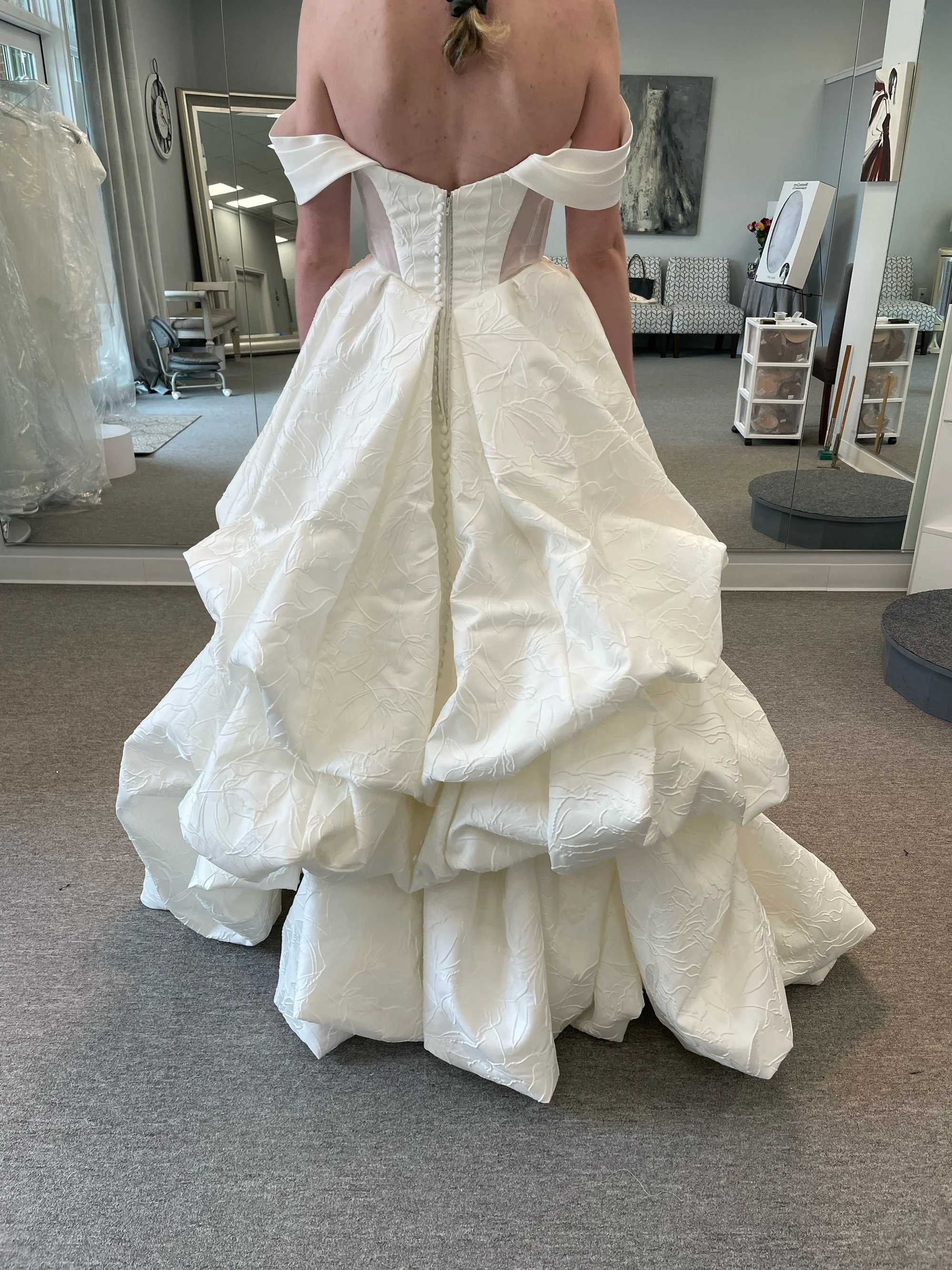 A field of white daisies with yellow centers, some in bloom and some in bud, set against a warm, golden background.