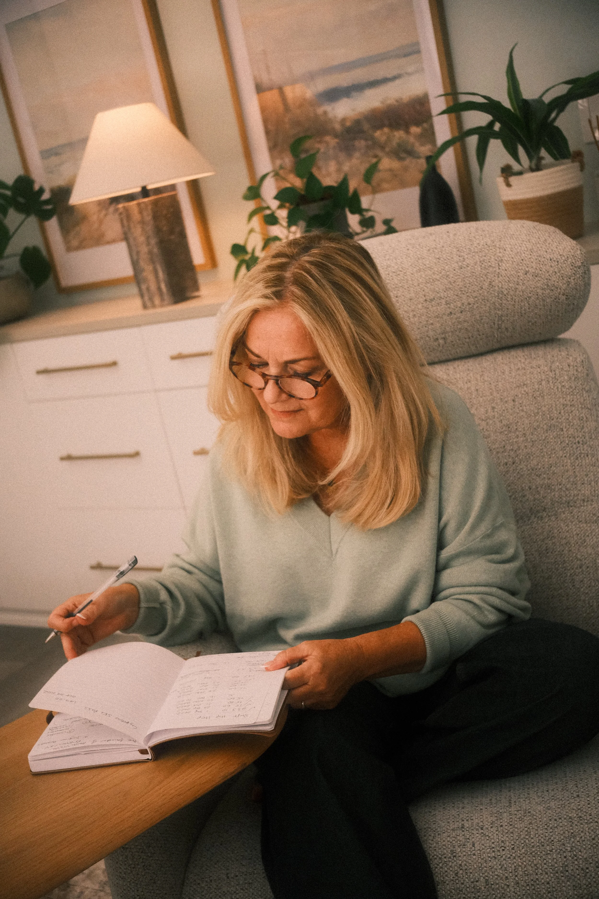 Denise Mosawi sitting in her office, writing notes