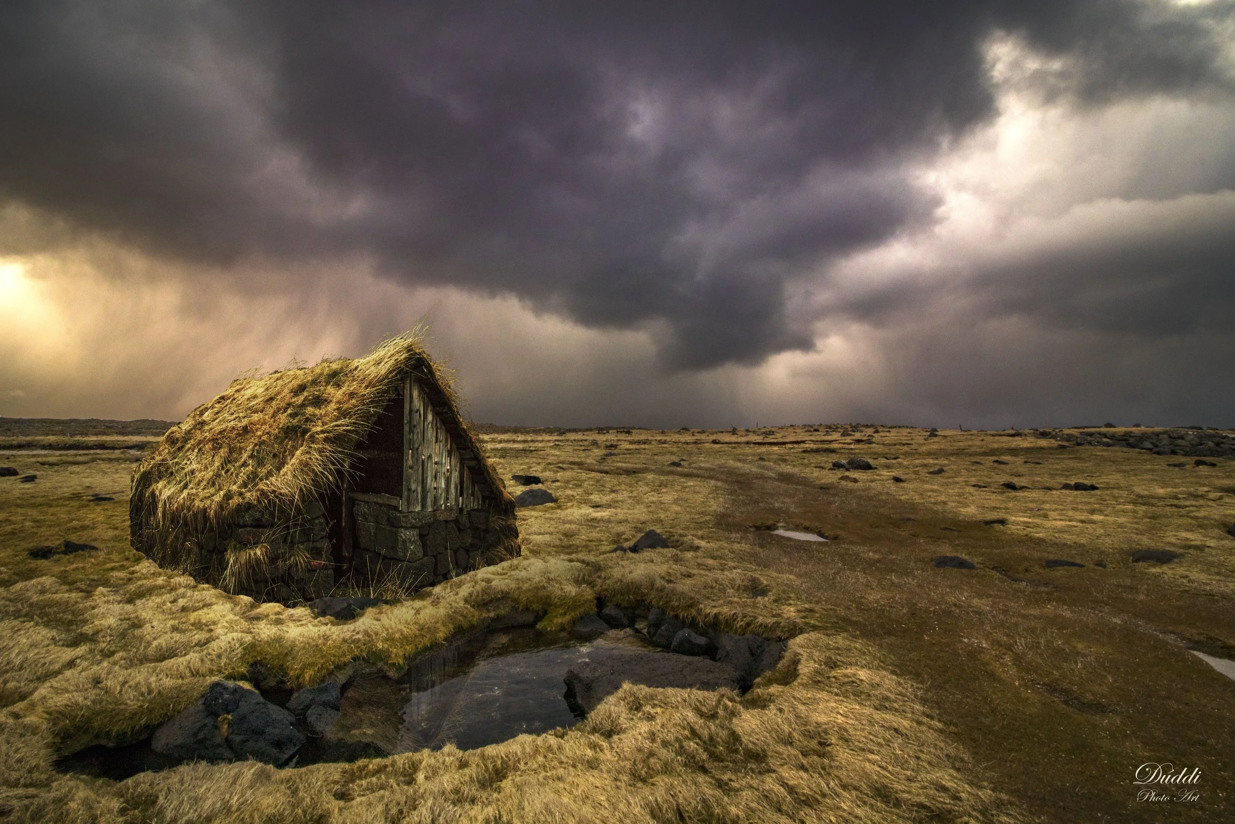 An old turf house in Iceland. Storm coming in the background