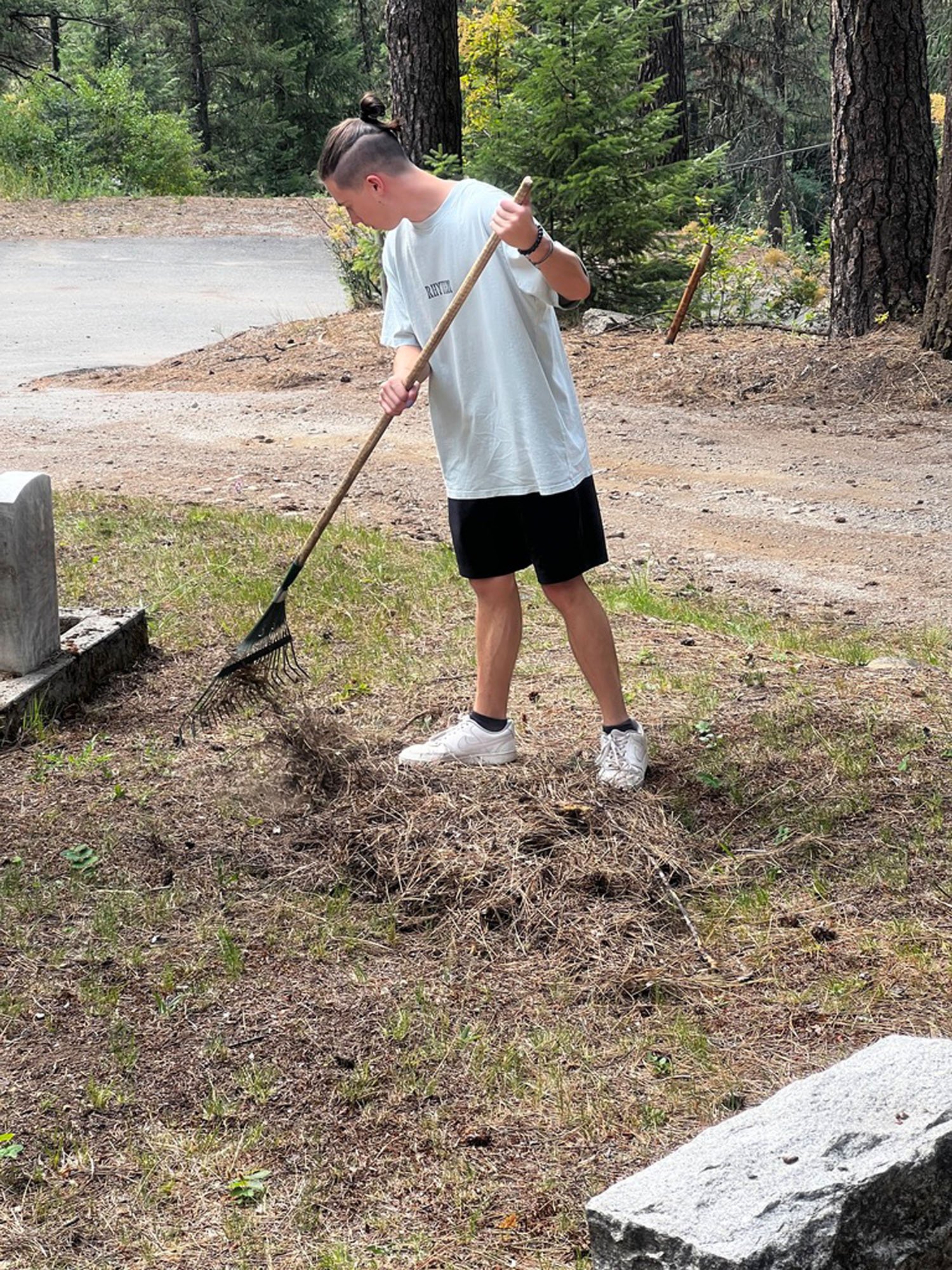 Trinity student raking during a youth group service trip