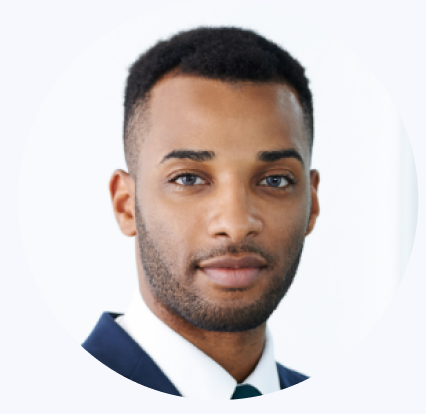 Close-up of a young African American man with short hair, beard, wearing a dark suit and white shirt, against a light background.