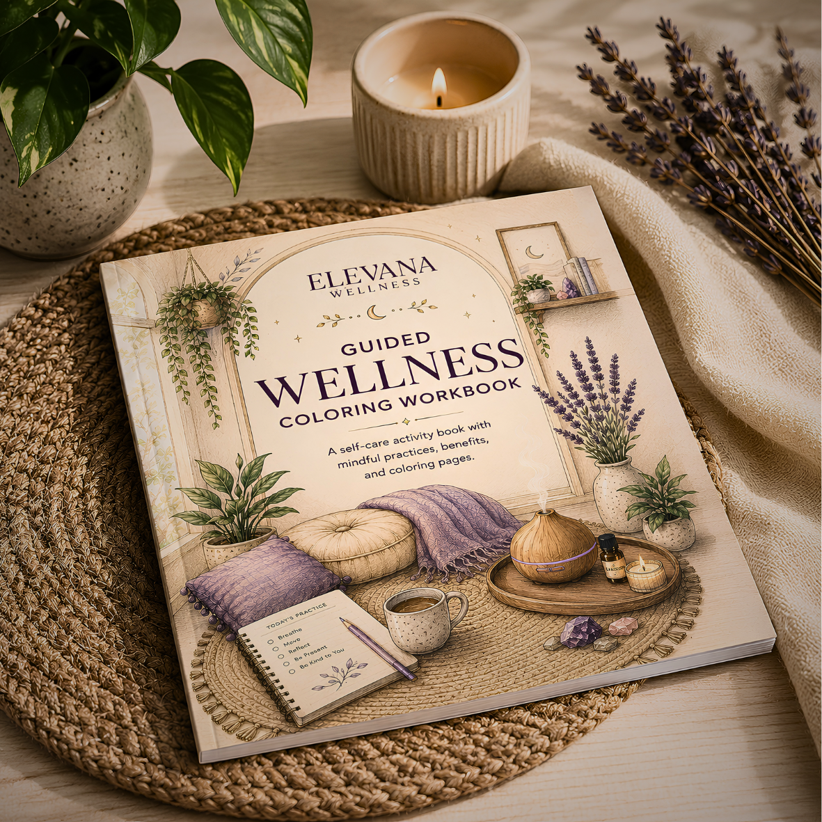 A wellness guided coloring workbook titled 'ELEVANA WELLNESS' on a woven placemat, surrounded by plants, a lit candle, lavender, crystals, and a tea cup, with a notepad and pen on the cover.