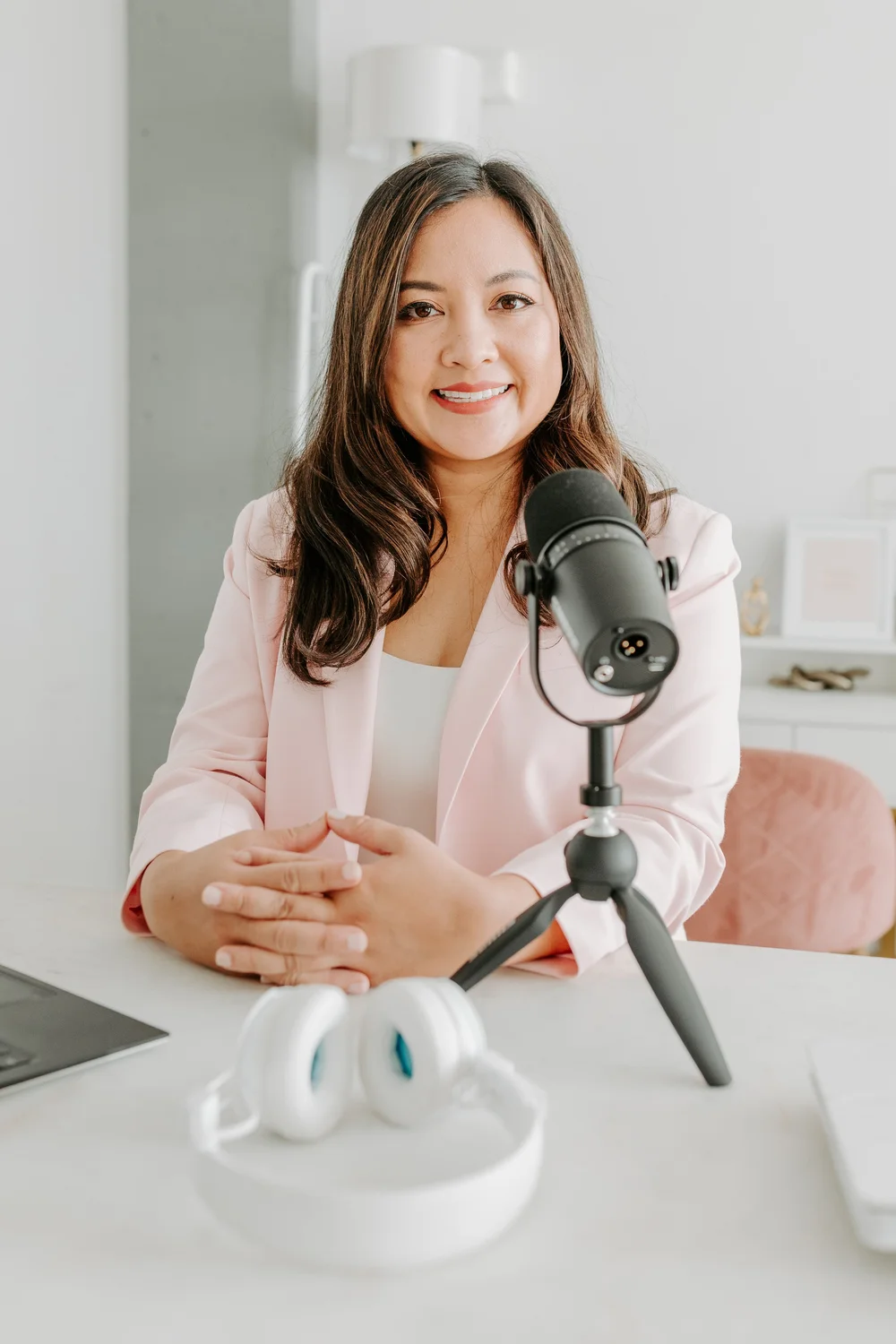 Dr. Valerie Cacho, MD, smiling behind a podcast microphone