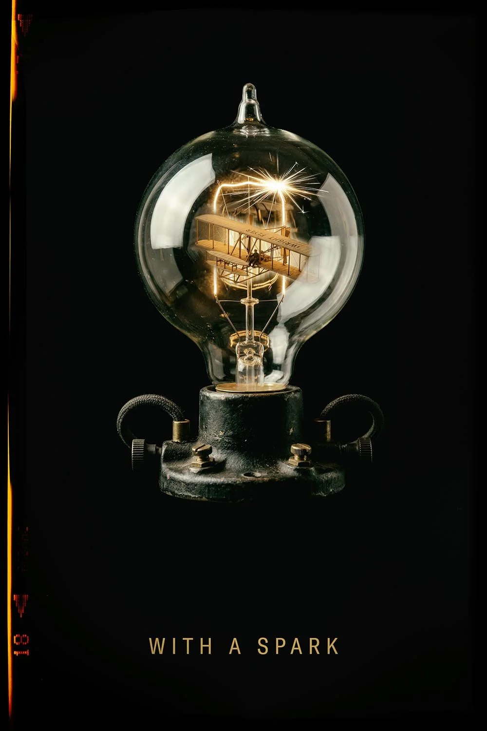 A vintage light bulb containing a model of the Wright brothers' airplane with a spark inside, against a black background, with the text 'WITH A SPARK' at the bottom.