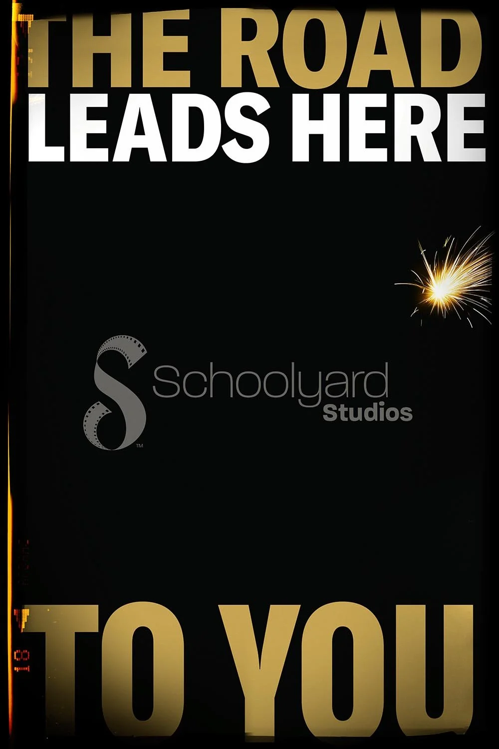 Poster with large gold and white text that reads 'The Road Leads Here To You' against a black background, with a small spark or firework to the right.