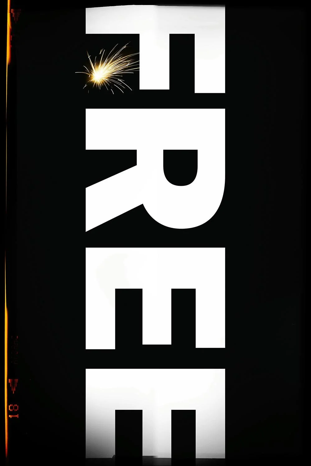 A black poster with bold white block letters spelling 'FREE', with a lit sparkler positioned next to the letter 'F'.