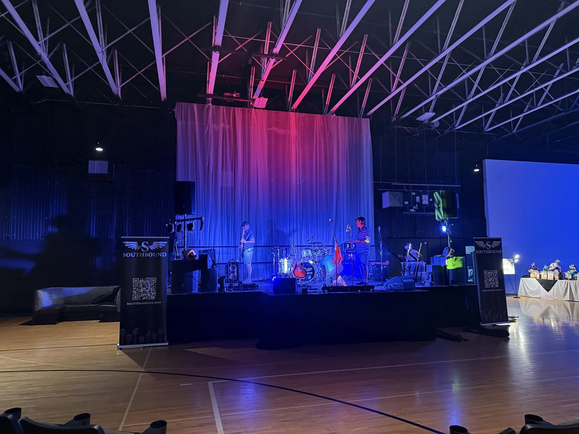 Stage set up with musical instruments and purple lighting, inside a large hall. Bands and sound equipment visible, with banners reading 'Southbound' in front.