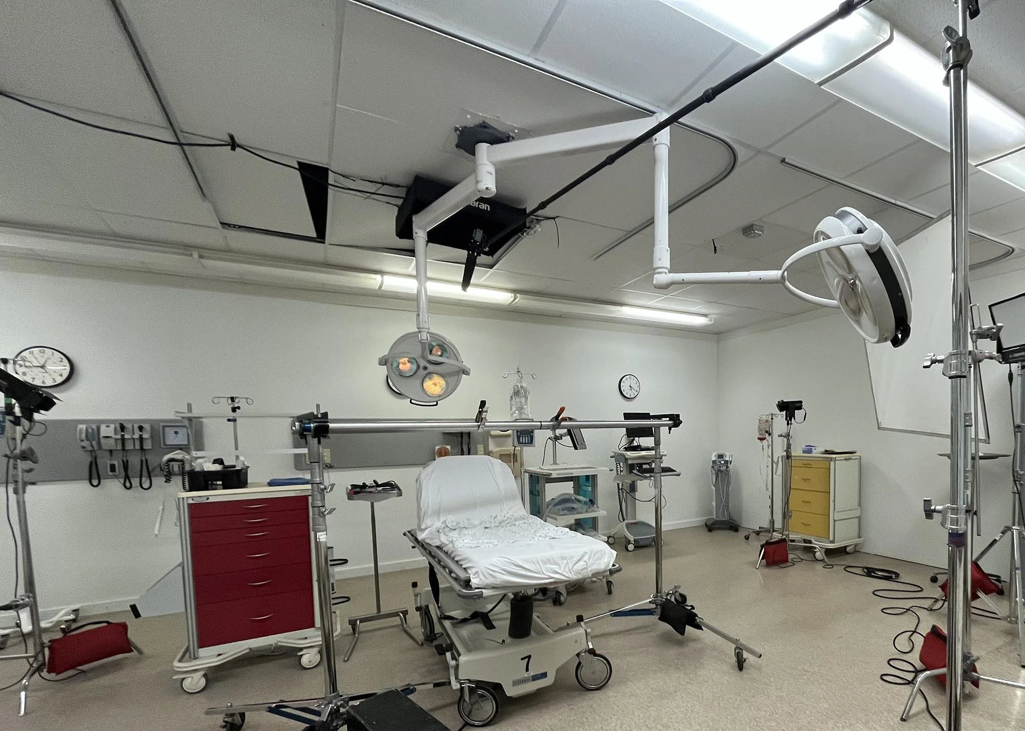 Hospital room with medical equipment, a patient bed, and surgical lights.