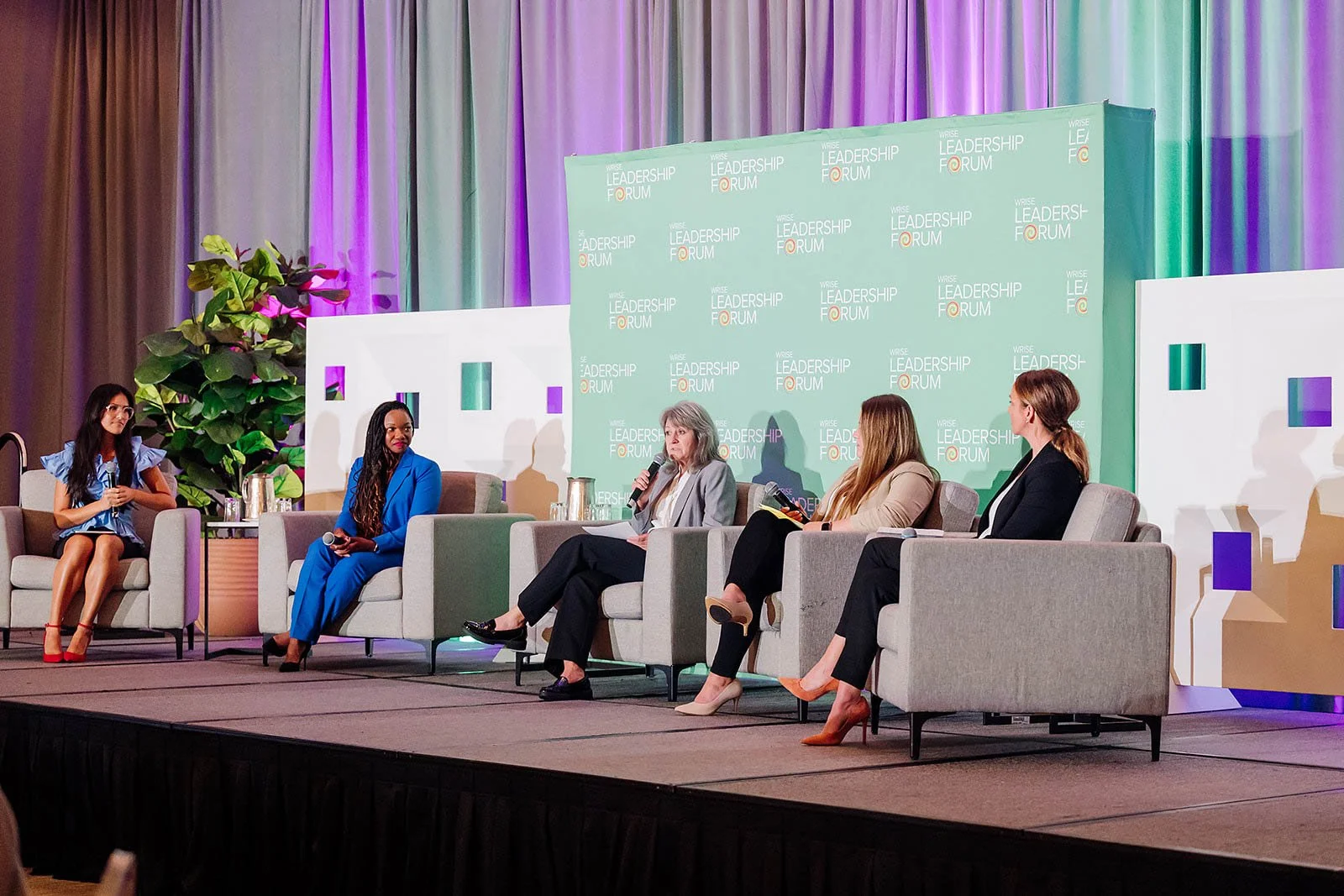 Several people talking on a stage at a conference