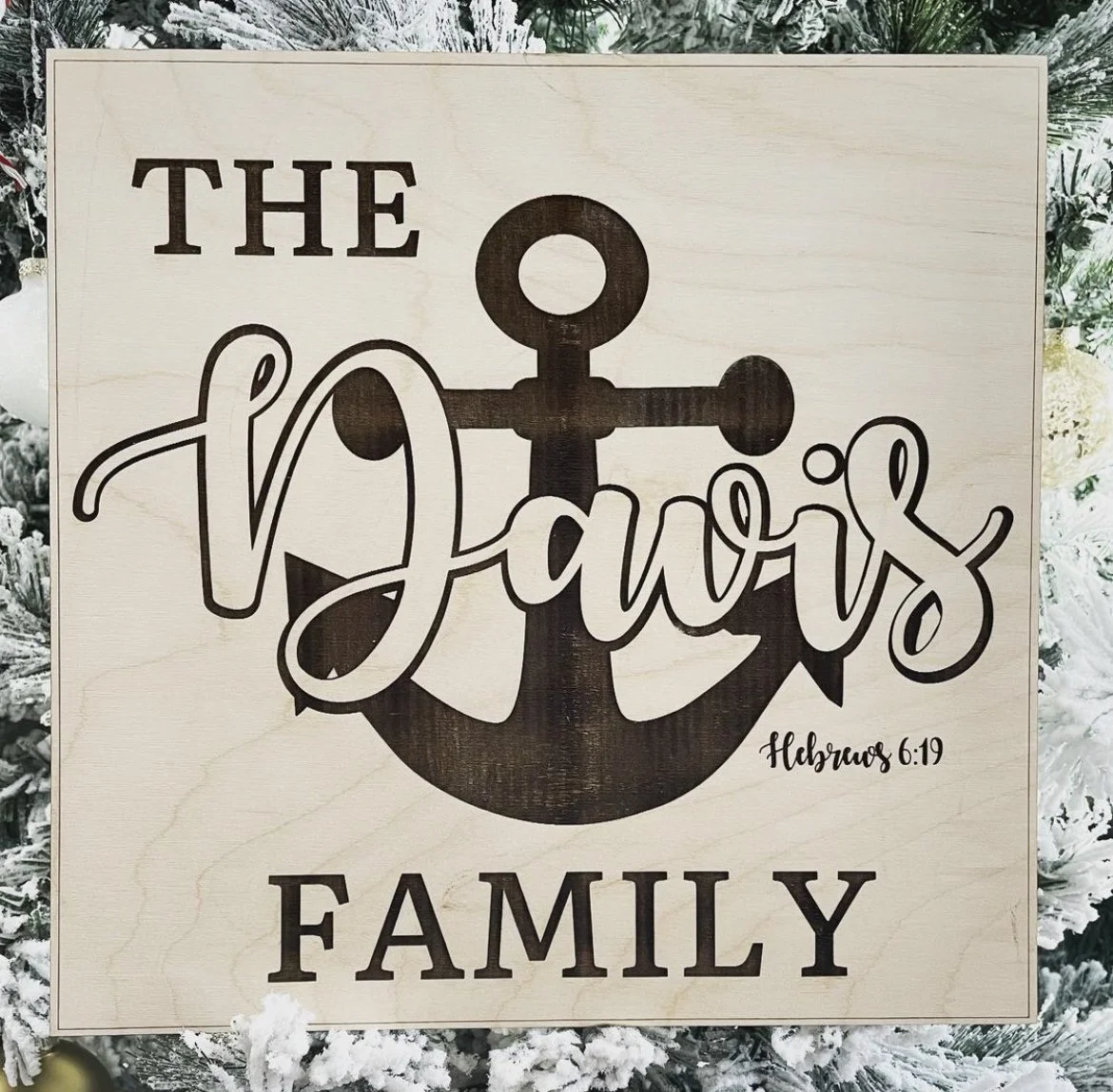 A decorative sign with a large anchor in the background. The sign reads 'The Davids Family' with a Bible verse reference 'Hebrews 6:19' in smaller text.