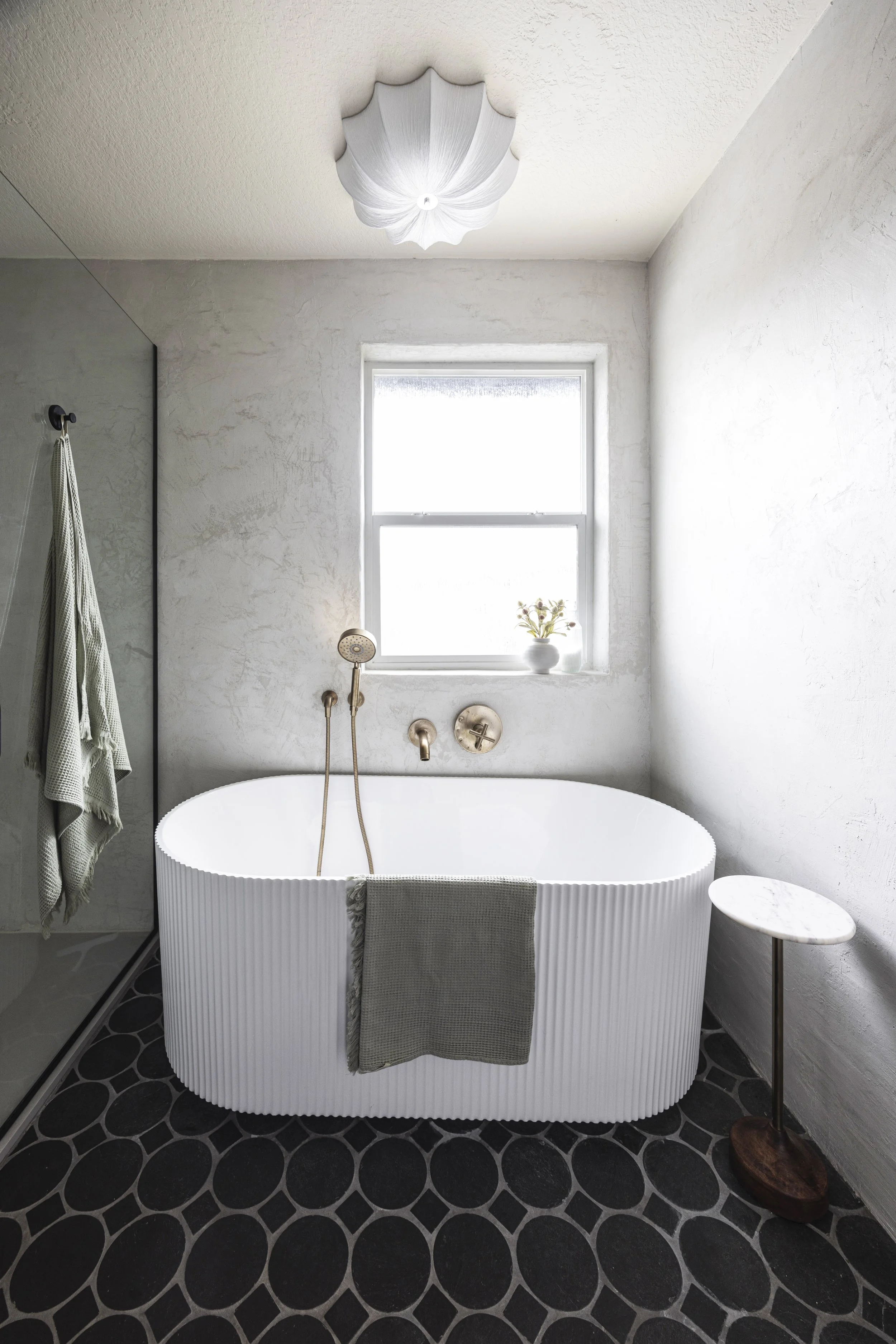 Bathroom with freestanding tub, black slate floor tile in a circle-and-square pattern, and brass fixtures, Portland, Oregon