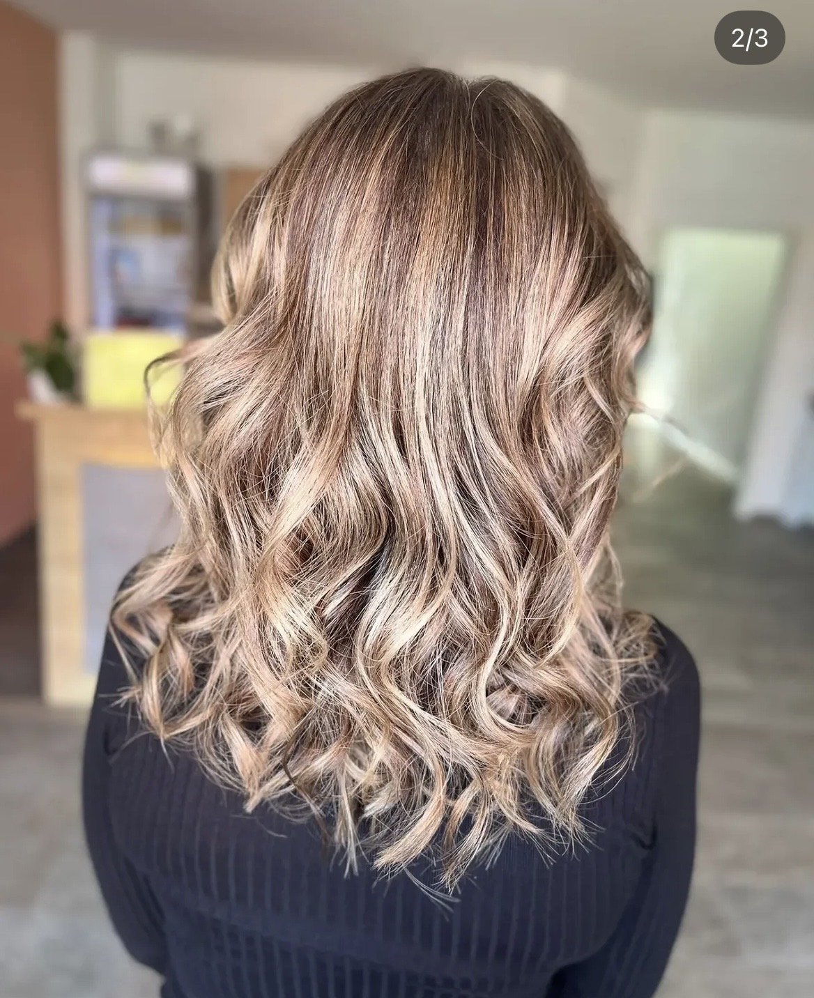 Haarfarbe mit hellblonden, karamellfarbenen und braunen Strähnen, lockige Haarstruktur