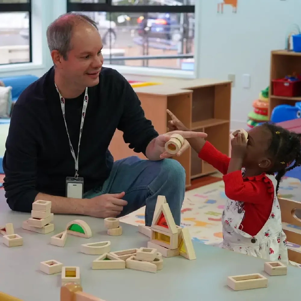 Teacher and two girls building with wooden blocks