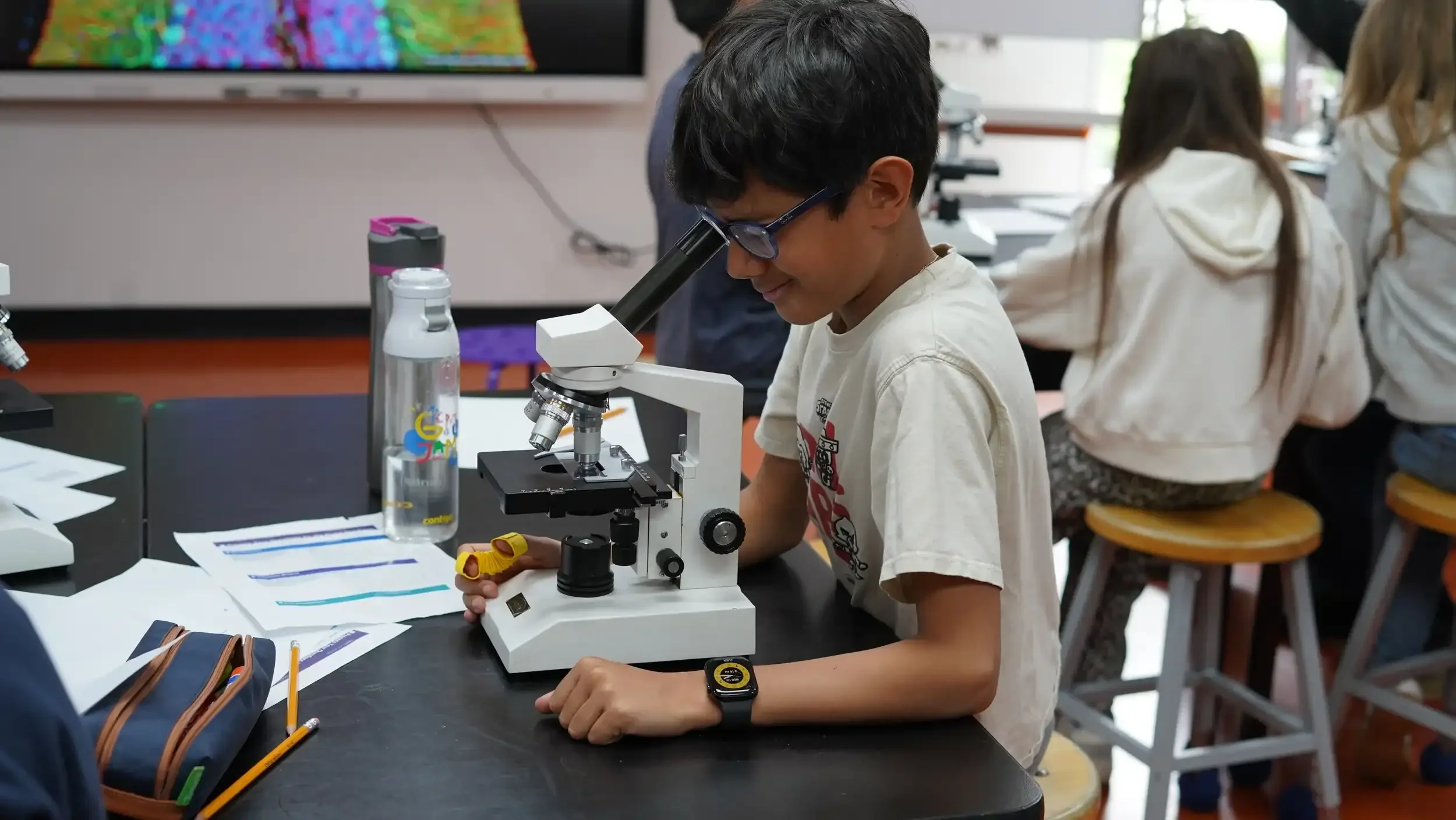 FASPS student looking through a microscope in the science lab