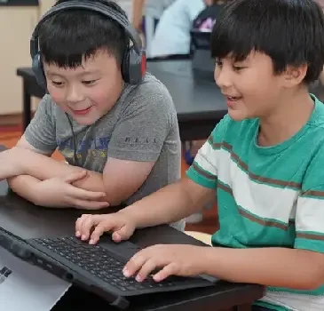 Two FASPS students working together on a laptop in class