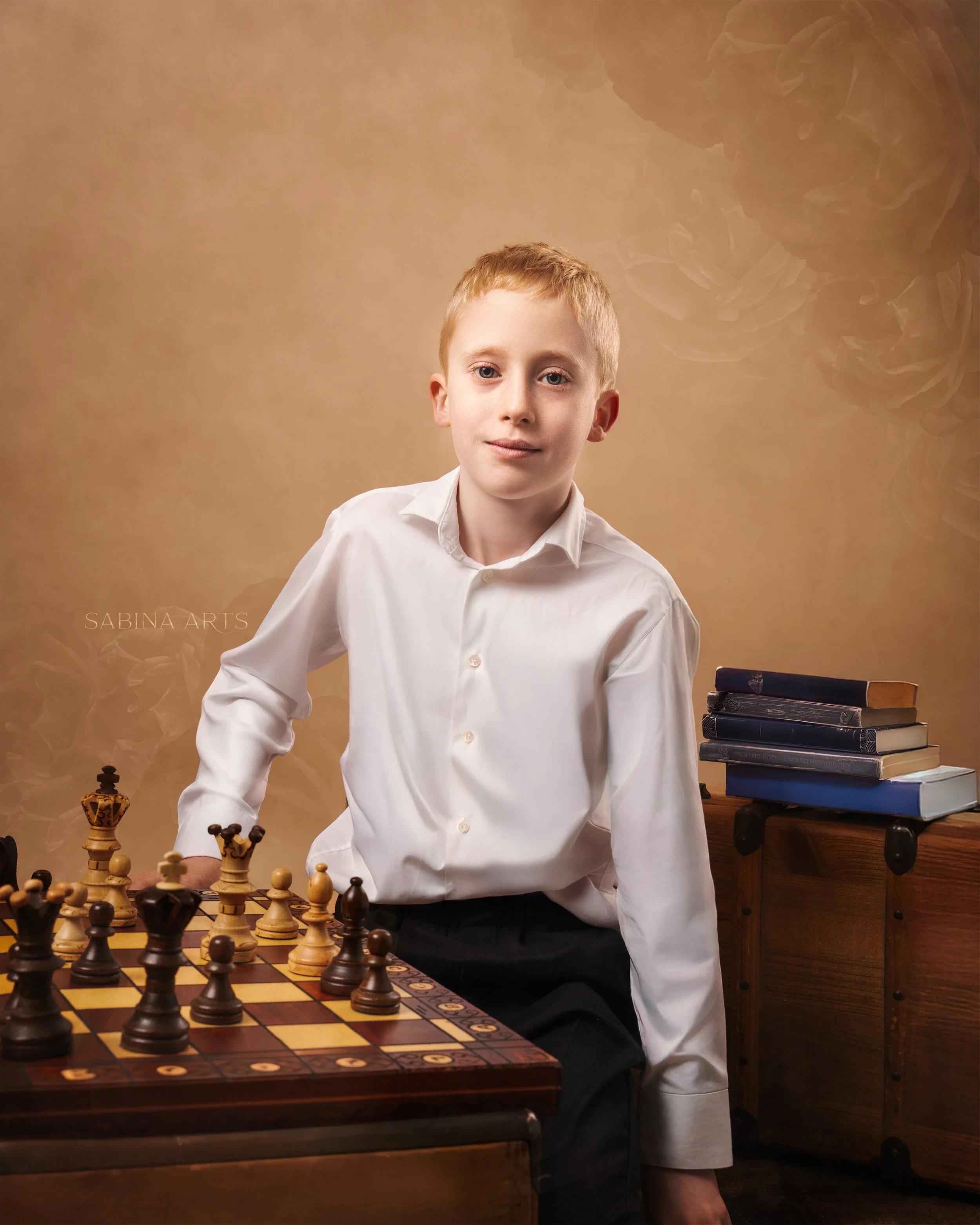 A young boy with red hair and blue eyes, wearing a white shirt, stands next to a chessboard with chess pieces, in a room with a stack of books on a small table. A golden decorative item is visible in the bottom left corner, and a backdrop with a flor