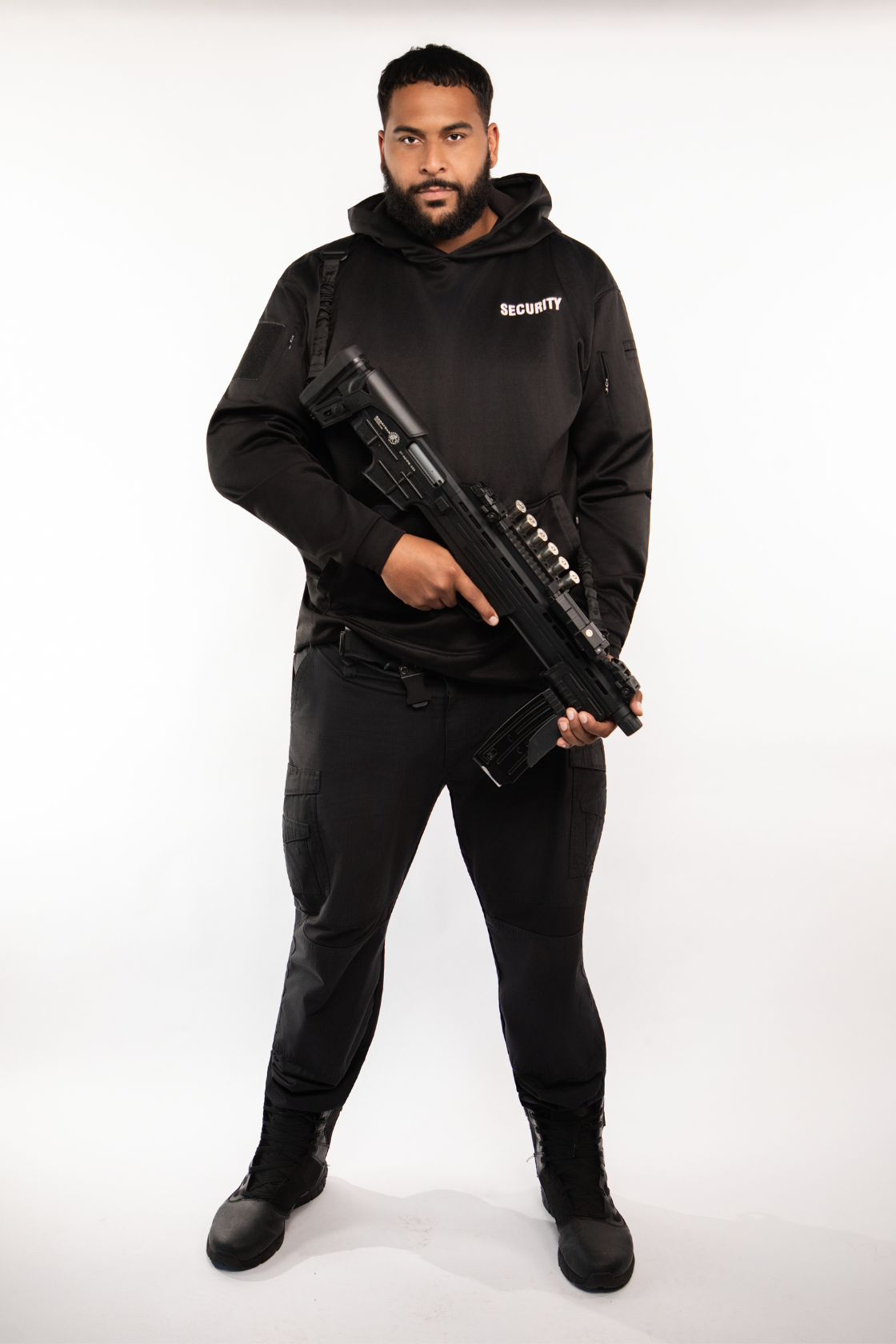 A man dressed in security guard uniform holding a rifle.