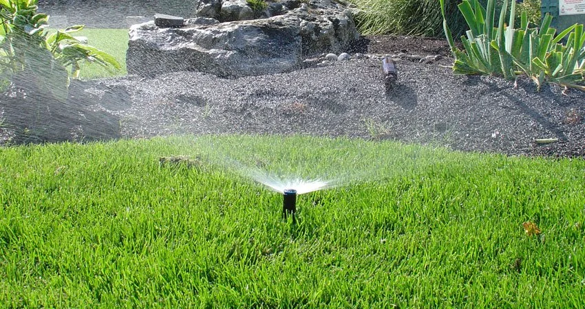 A sprinkler watering a lawn after an irrigation system repair in Toronto, Ontario.