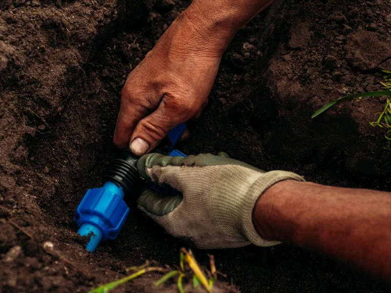Technician repairing a broken sprinkler head and checking for leaks in Toronto, Ontario