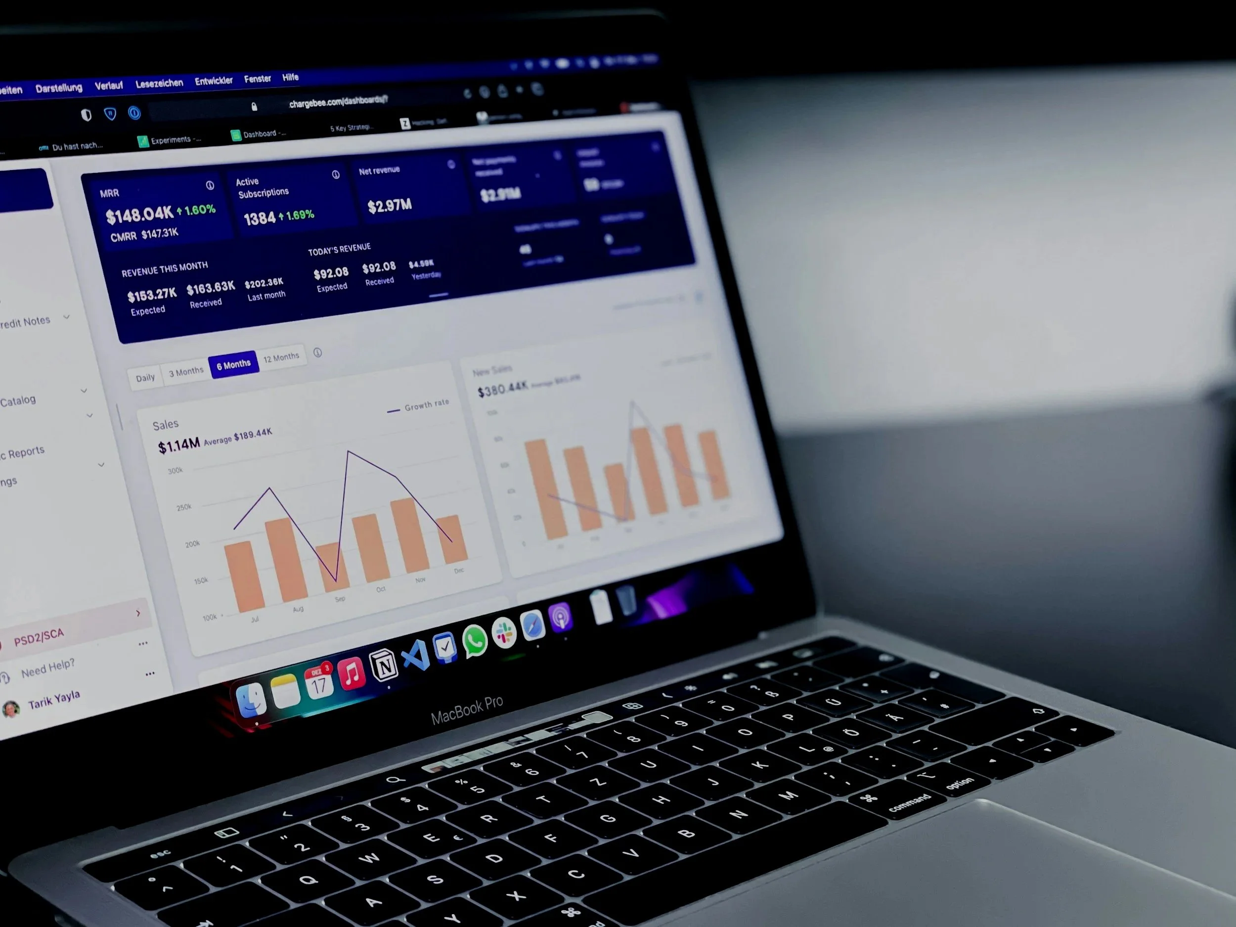 Laptop screen displaying a dashboard with financial data, graphs, and statistics in a dark mode interface.