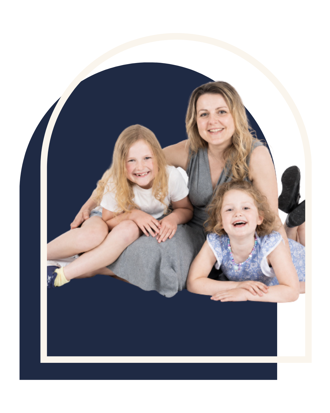 Photo of a smiling woman with two young girls, one on each side, all lying on the floor and posing for the camera.