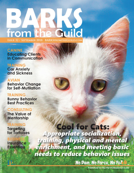 Magazine cover of 'Barks from the Guild' featuring a close-up of a white cat with yellow eyes against a blue sky background, issue 32 from September 2018.