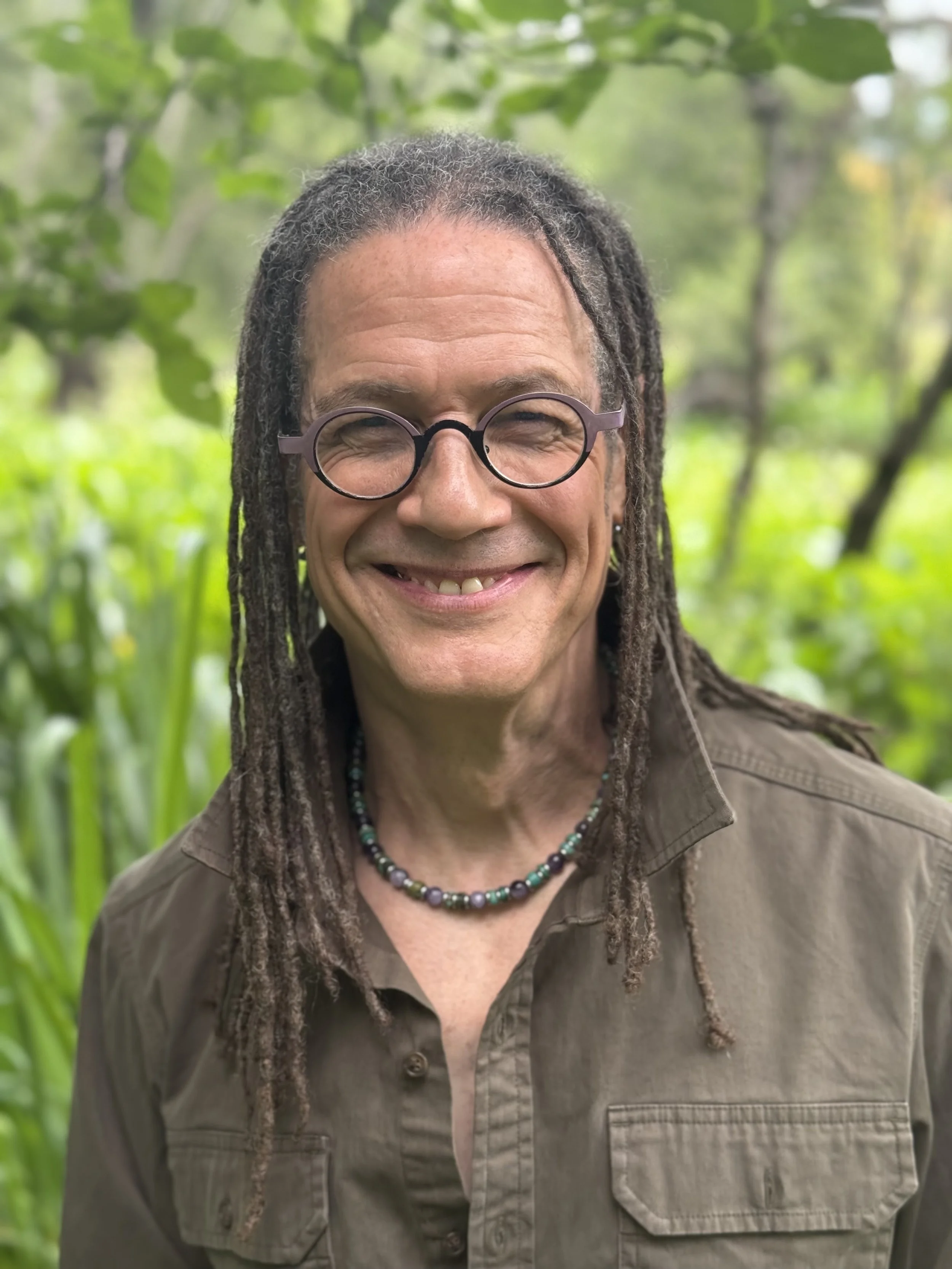 Photo Of Taylor, smiling, surrounded by nature,  waiting for you get in touch for a complementary Life Coaching Session!