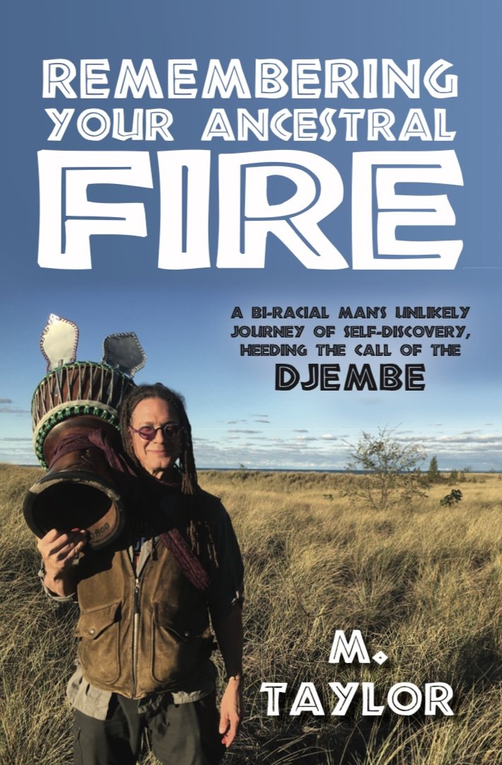 Book cover titled 'Remembering Your Ancestral Fire: A bi-racial man's unlikely journey of self-discovery, heeding the call of the Djembe' by M. Taylor. The cover features a man with dreadlocks wearing sunglasses, holding a Djembe drum, standing in a grassy landscape with a clear blue sky.