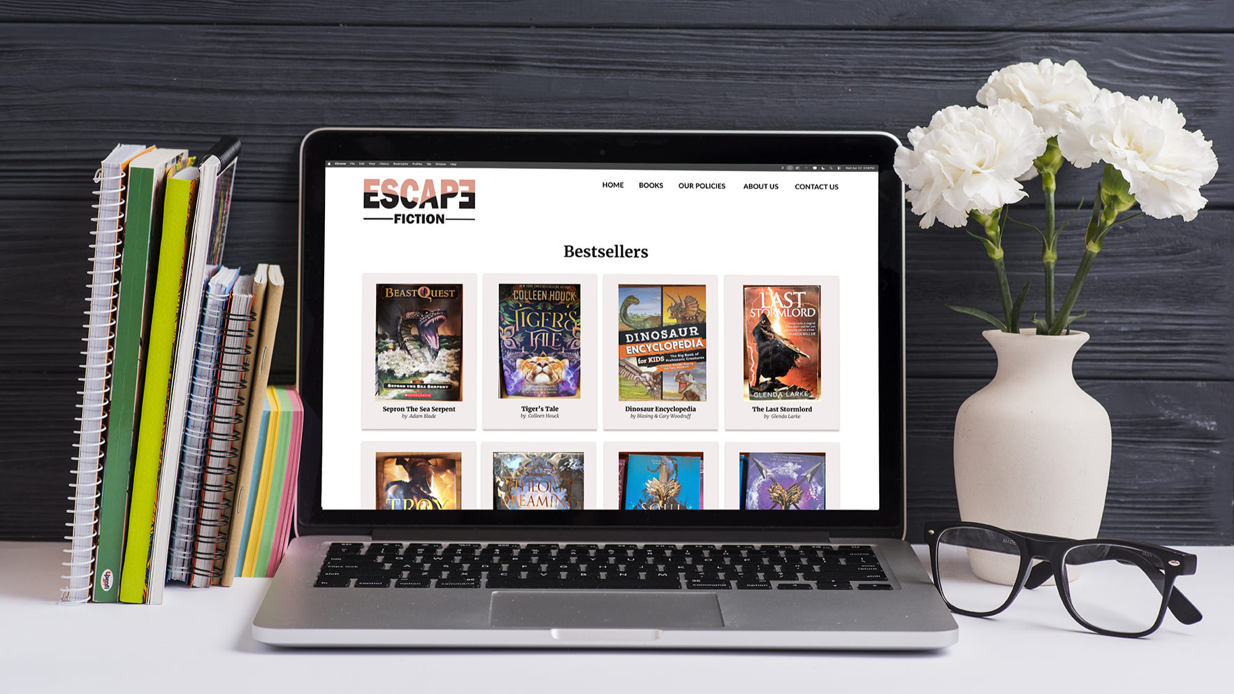 books-adhesive-notes-laptop-eyeglasses-vase-white-desk-against-wooden-wall+copy.png