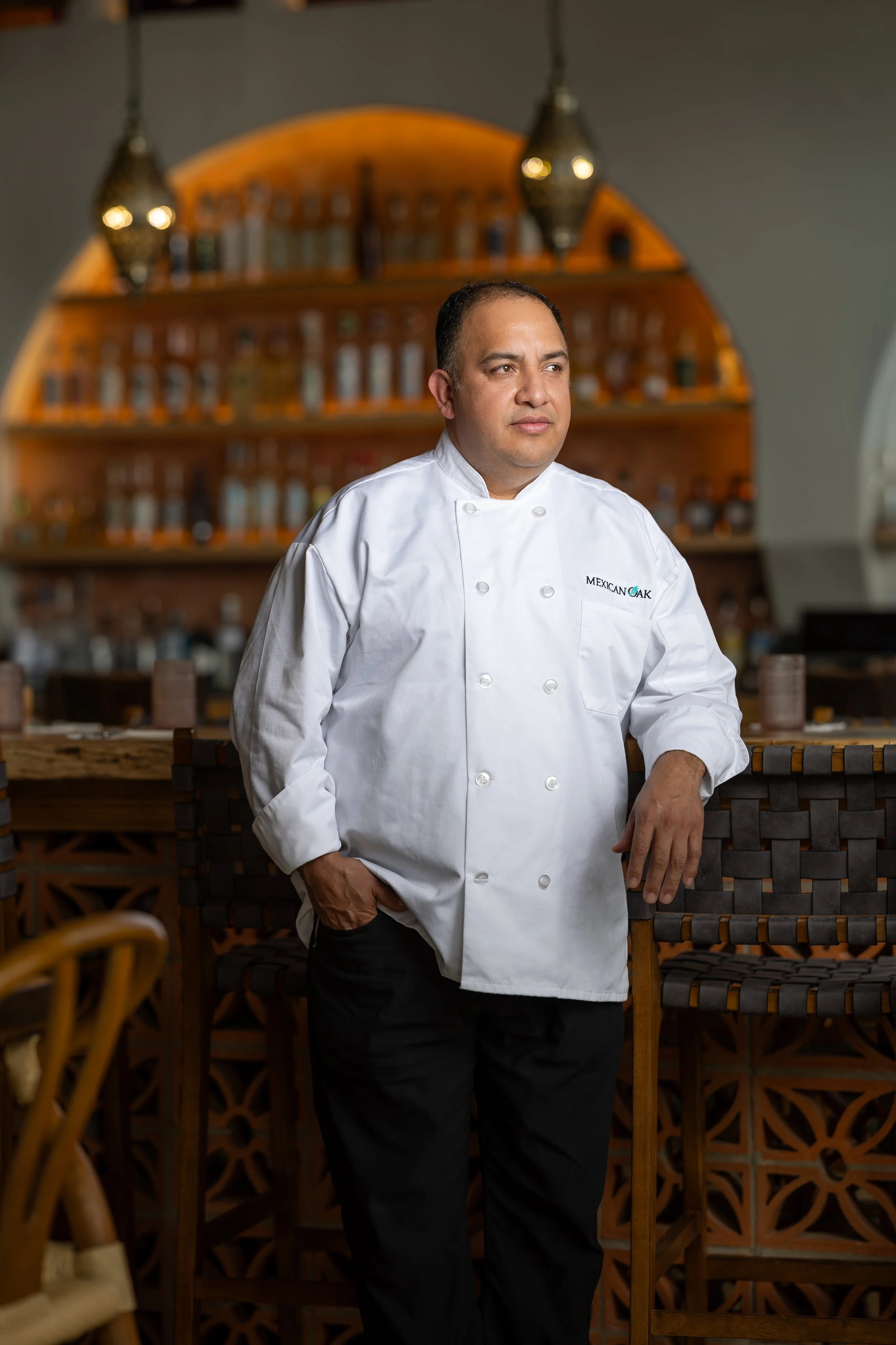 A male chef wearing a white chef's coat with 