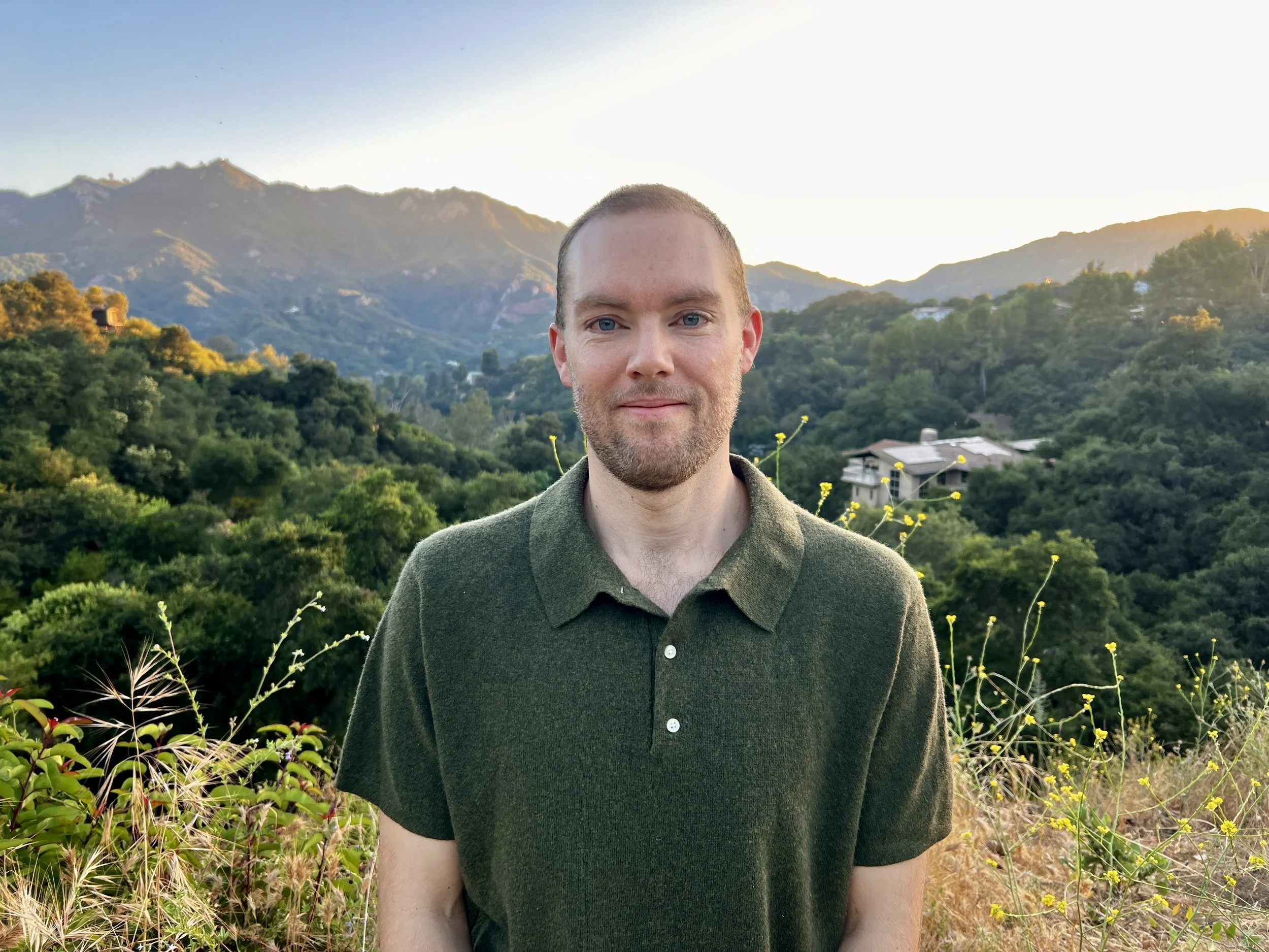 Henry Bond standing outdoors in the hills of Topanga Canyon at sunset.