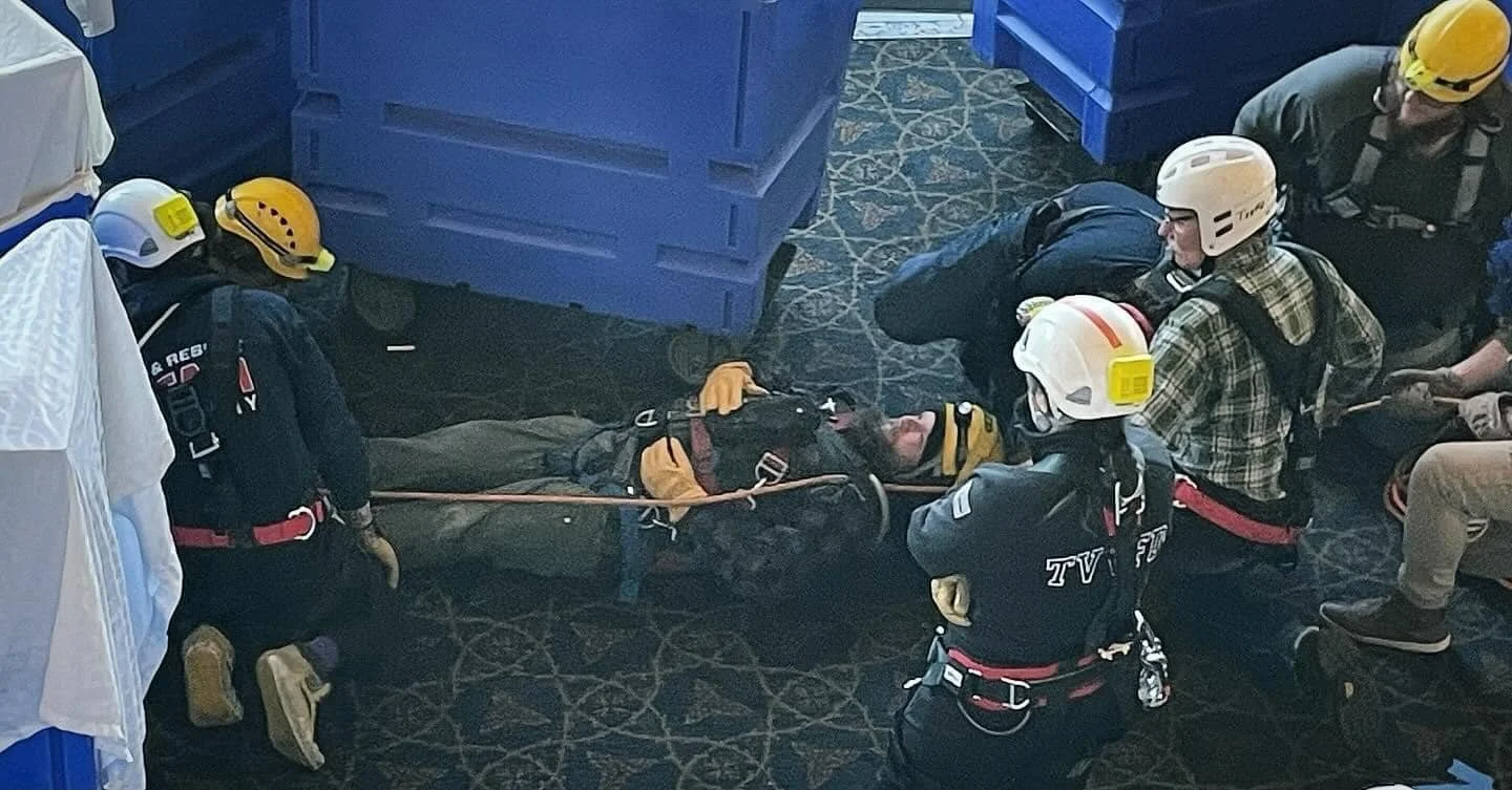 Emergency responders attending to a person lying on the floor during a rescue effort.