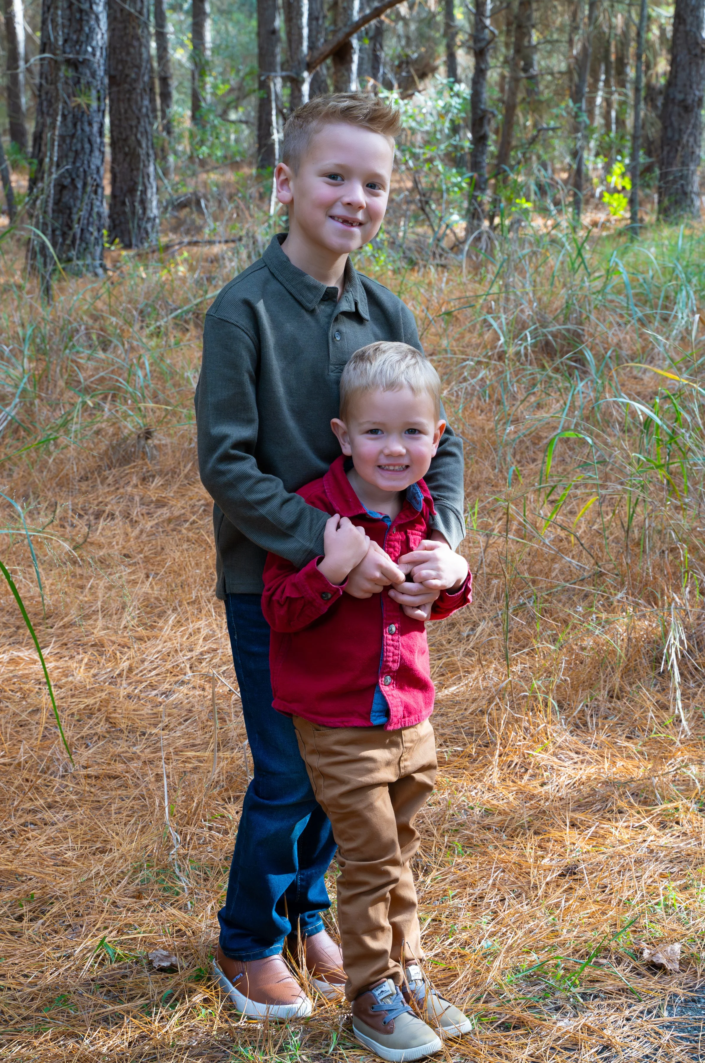 Adult holding toddler while walking in the woods