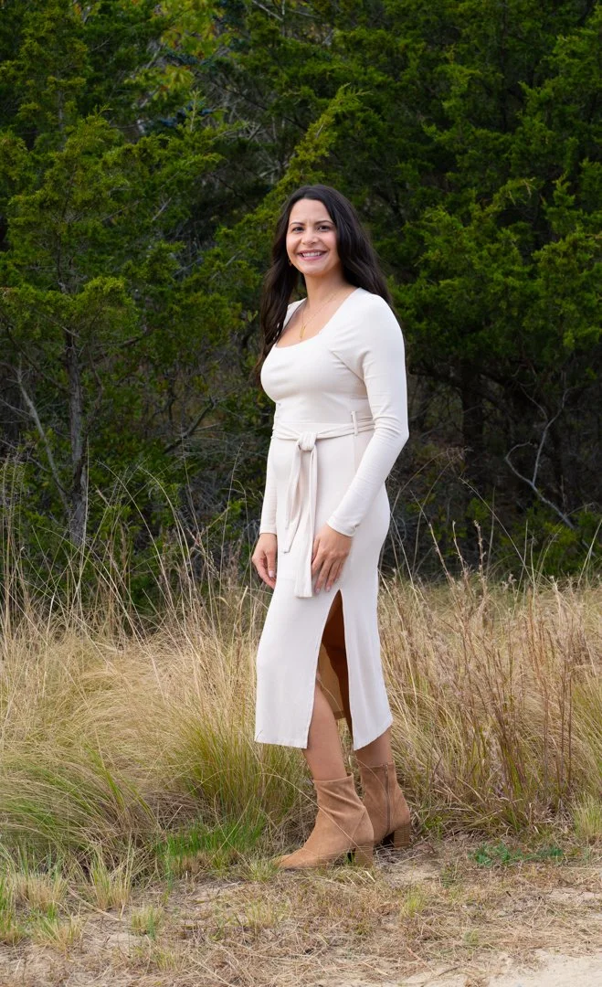 Woman in a white dress standing in a grassy field